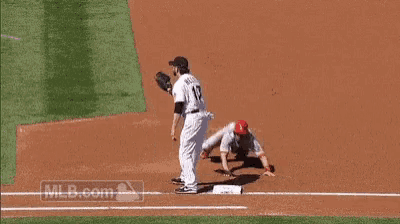 a baseball player with the number 17 on his jersey is trying to catch a ball .