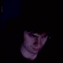 a close up of a man 's face in the dark with a smile on his face .