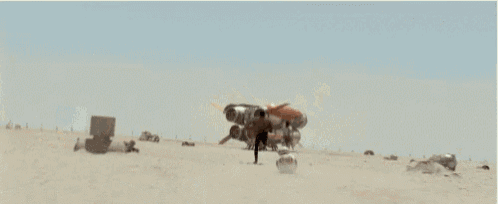 a man and a woman are running in the desert holding a sword .