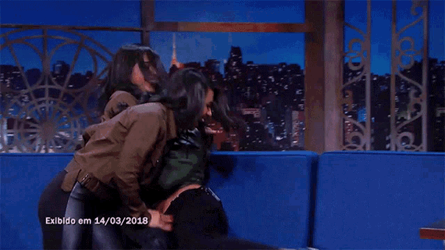 three women are sitting on a blue couch with the date 14/03/2018 on the bottom