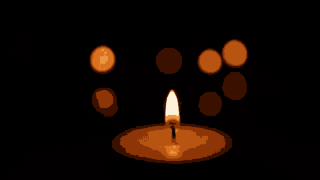 a candle is lit up in the dark with a few candles in the background