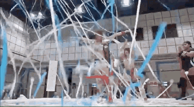 a group of wrestlers are fighting in a wrestling ring surrounded by confetti .
