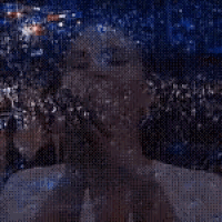 a woman is covering her mouth with her hands in front of a crowd of people .