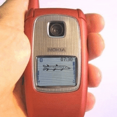 a person is holding a red flip phone in their hand .