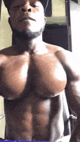 a shirtless man is taking a selfie in front of a mirror with his huge muscles exposed .