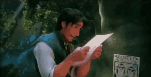 a man is reading a letter in front of a wanted poster .