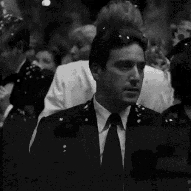 a man in a suit and tie is standing in a crowd