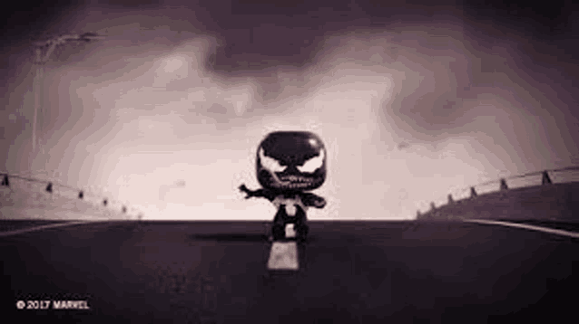 venom is riding a skateboard down a road .