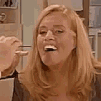 a woman is making a funny face with her mouth open and a fist in her hand .