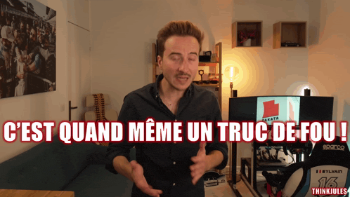 a man in a black shirt is standing in front of a sign that says c'est quand meme un truc de fou