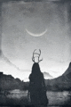 a black and white photo of a person with antlers looking at the moon .