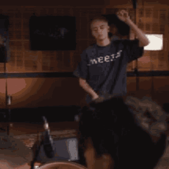 a man in a blue shirt that says wise is dancing in a room