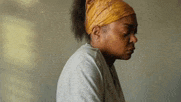 a woman wearing a headband and a white shirt is sitting down .