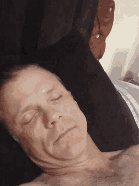 a man with his eyes closed is laying on a pillow