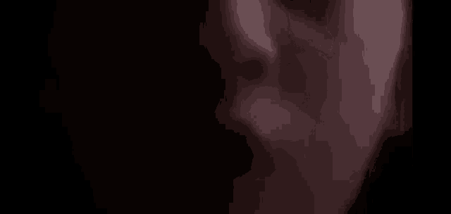 a close up of a person 's face in the dark with a blurry background .