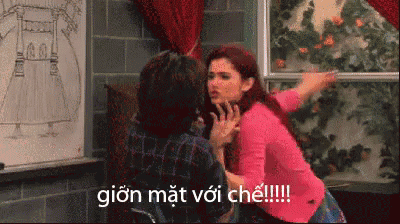 a woman in a pink sweater is fighting with a man in a plaid shirt and the words gion mat voi che are visible