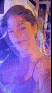 a woman 's face is shown in a blurry photo with a purple background