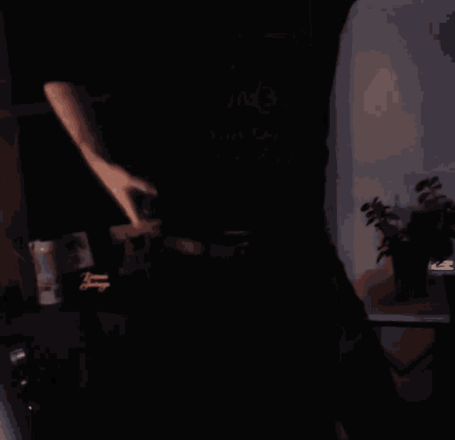 a blurry picture of a man dancing in front of a blackboard that says " all " on it