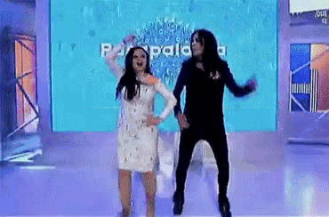 a man and a woman are dancing on a stage in front of a screen that says parpala