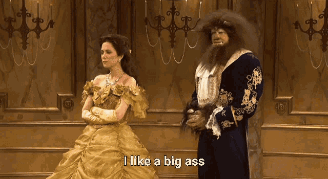 a woman in a ball gown stands next to a man in a beast costume