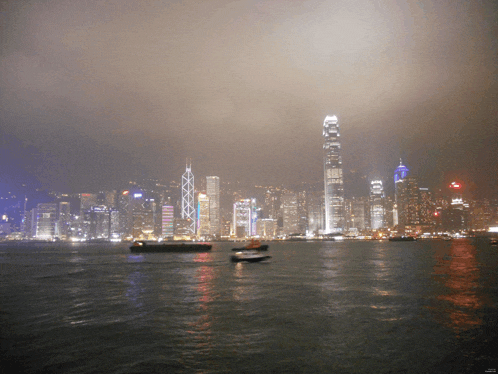 a city skyline with a few boats in the foreground