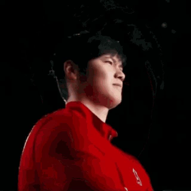 a close up of a man 's face with a red shirt on making a funny face .
