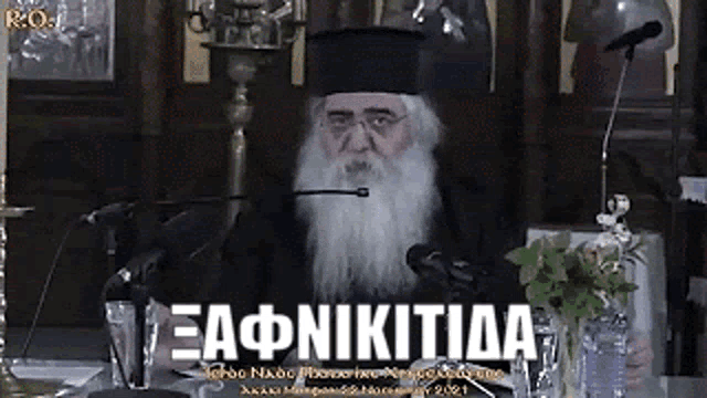 a man with a beard is speaking into a microphone in a church