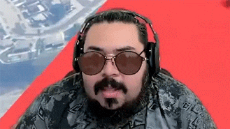 a man with a beard and sunglasses is wearing headphones and a camo shirt .