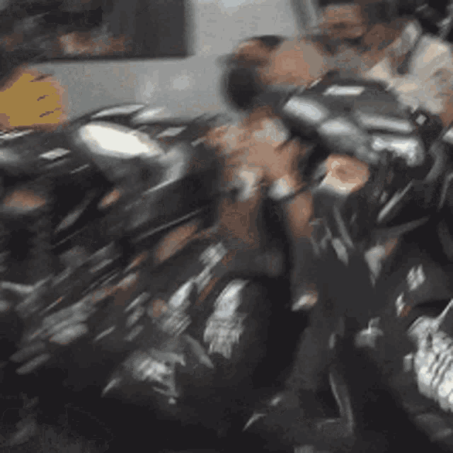 a blurry picture of a group of people fighting each other on a bus .