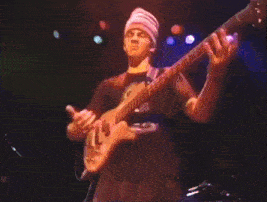 a man playing a guitar and another man singing on stage