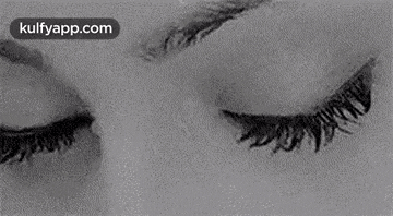 a black and white photo of a woman 's eyes looking at the camera .