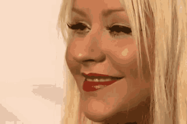 a close up of a woman 's face with blonde hair and red lips