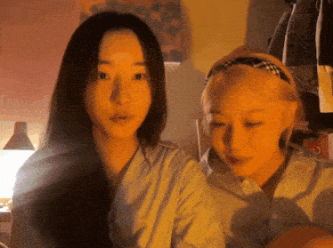 two women looking at each other with one wearing a headband
