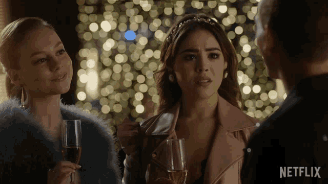 a woman holding a glass of champagne talks to a man in a netflix ad