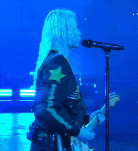 a person playing a guitar and singing into a microphone