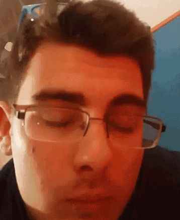 a man wearing glasses is looking down with his eyes closed