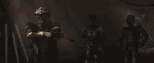 a man holding a gun in a dark room with another man behind him