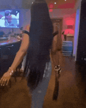 a woman in a black off the shoulder top and blue jeans