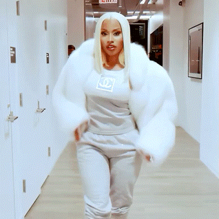 a woman with blonde hair and red lipstick is wearing a white fur coat .