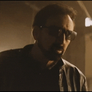 a man wearing sunglasses and a leather jacket is looking at the camera