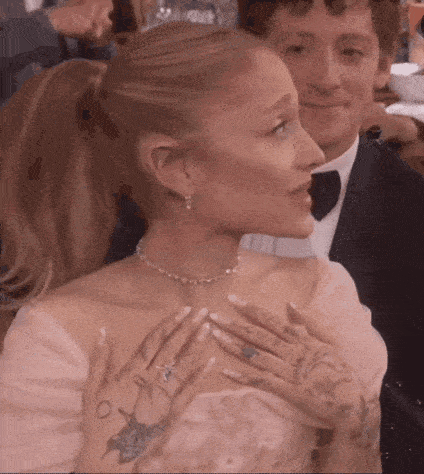 a woman in a pink dress is sitting next to a man in a suit and tie .