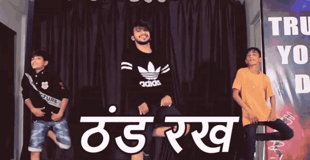 a group of young men are dancing in front of a sign that says trust you dance