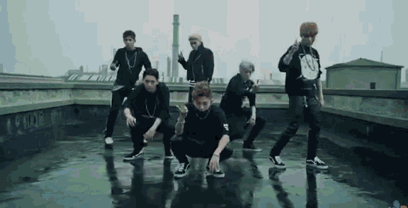 a group of young men are squatting on a wet roof