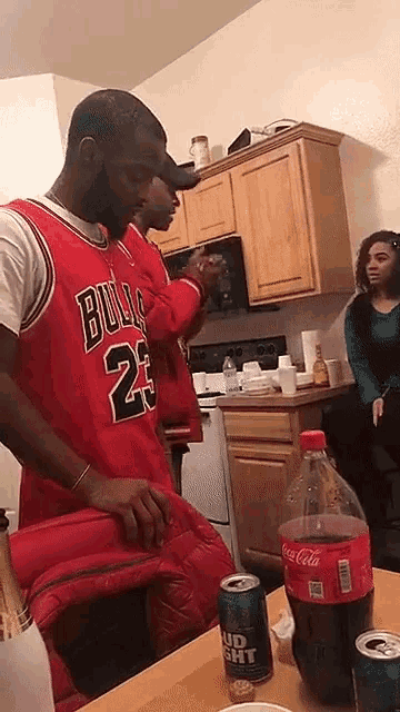 a man in a bulls jersey is standing next to a coca cola bottle