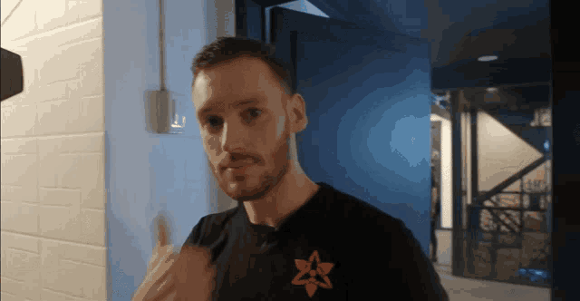 a man in a black shirt with an orange star on it