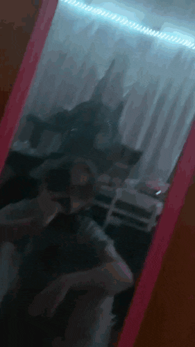 a person taking a picture of themselves in a pink mirror