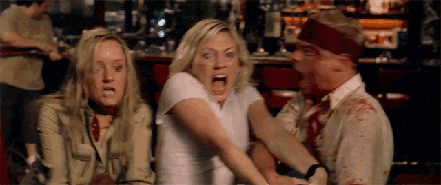 a man and two women are fighting in a bar with blood on their shirts