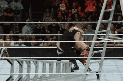 two wrestlers are in a wrestling ring with a referee and a crowd watching