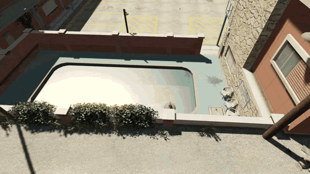 an aerial view of a swimming pool surrounded by a brick wall