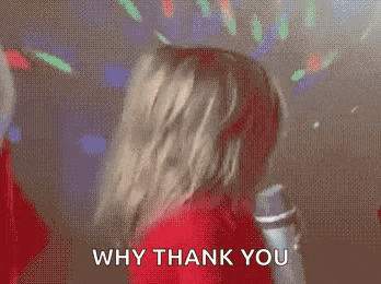 a little girl in a red shirt is holding a microphone and says `` why thank you '' .